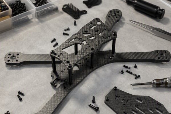 Carbon fiber drone frame plates being assembled on a workbench